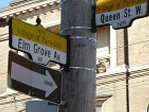 Street signs marking the intersection at Queen Street and Elm Grove